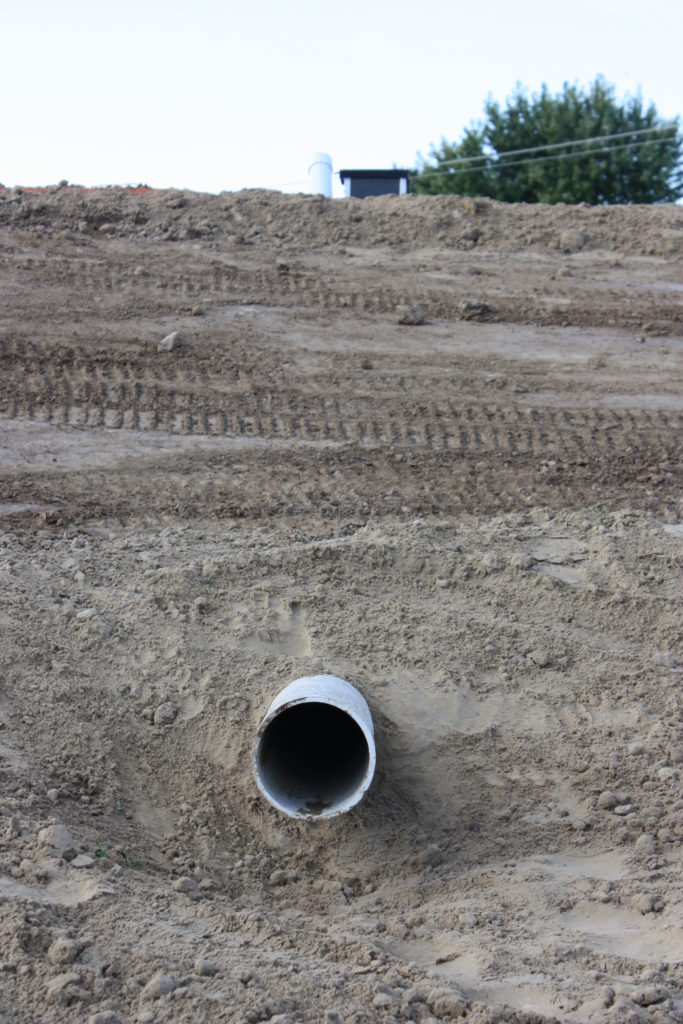 Backyard swim pond overflow water line closeup view