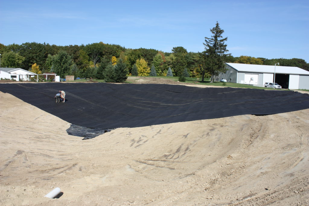 Backyard swim pond underlayment liner installation begins