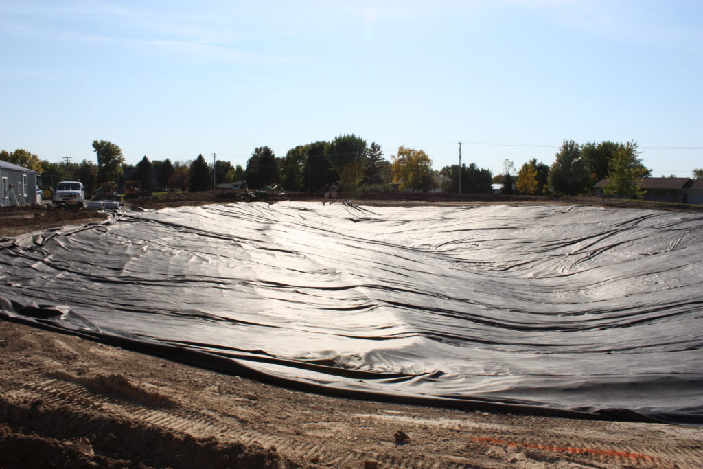 Backyard swim pond overlayment liner installation