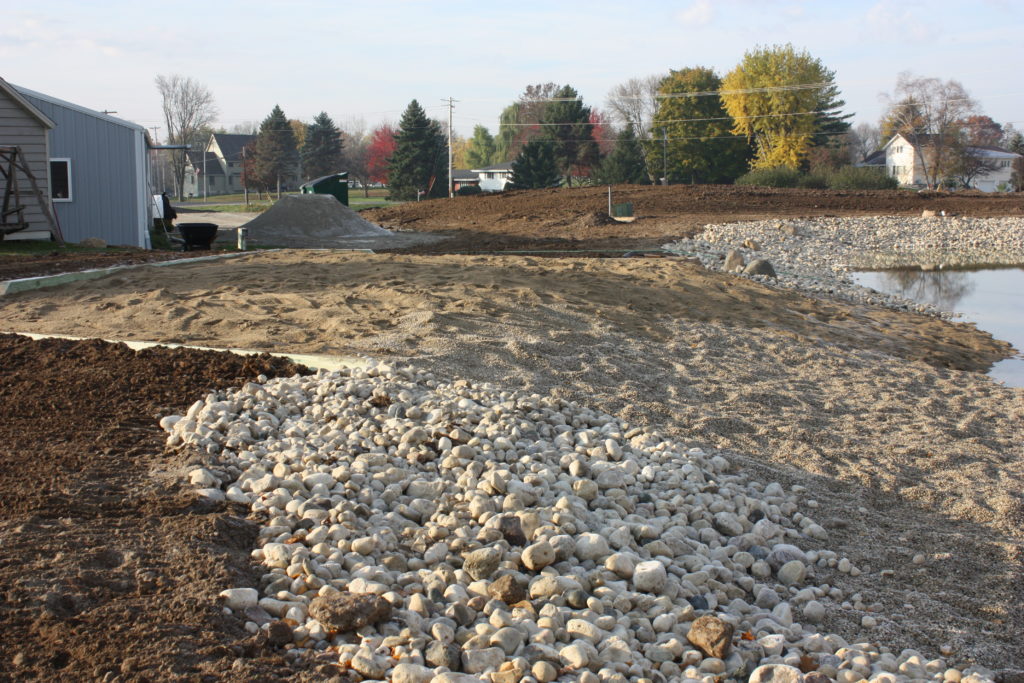 Backyard swim pond shoreline and beach view