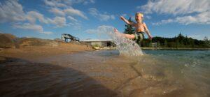 child jumping and splashing in pond